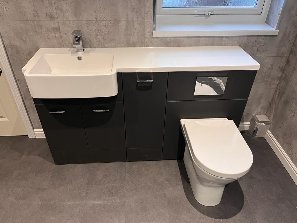 Loft bathroom with a sloped ceiling, white inset bath, marble-effect tiling and a black slate shower tray