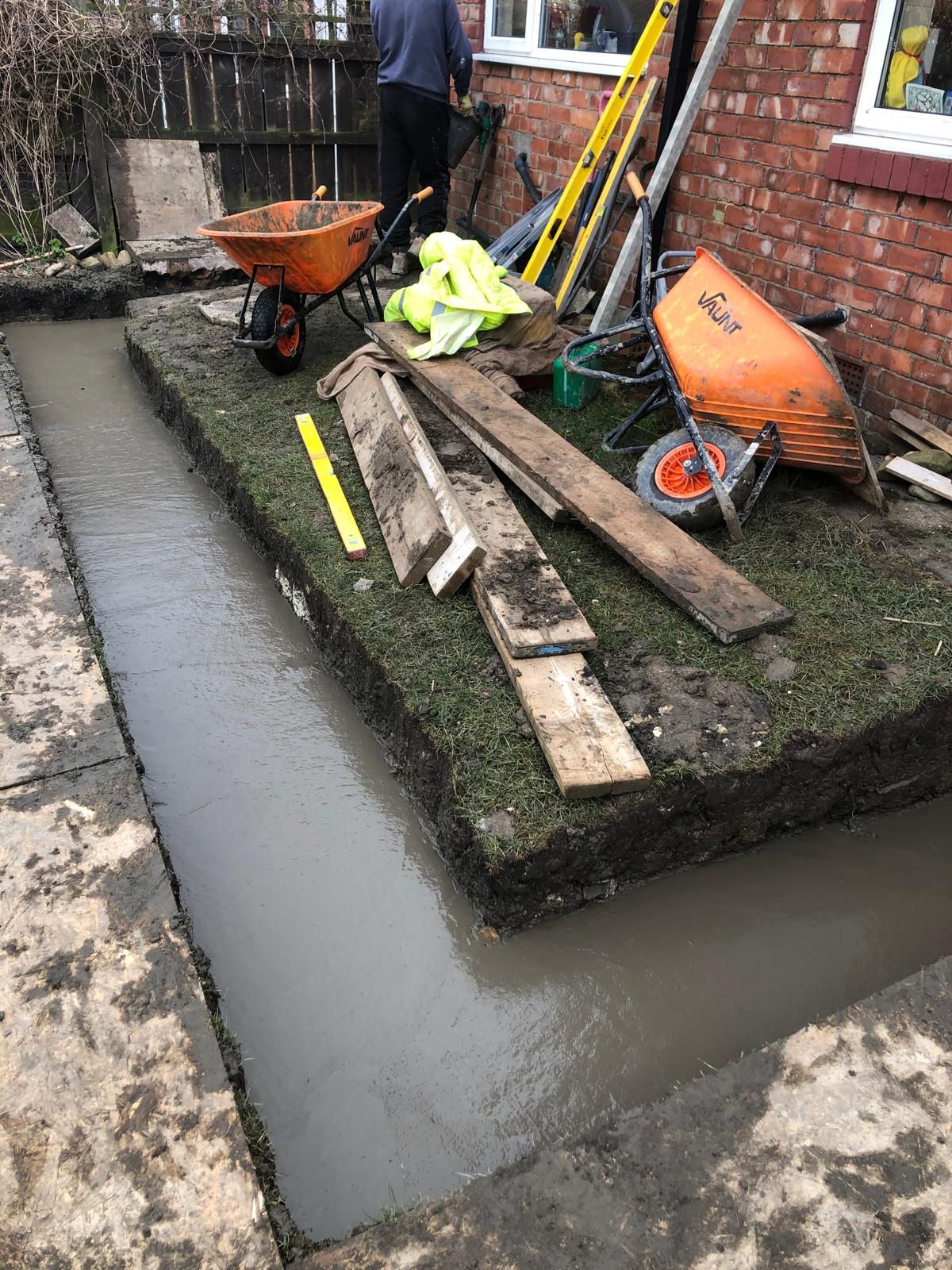 New red-brick and blockwork footings rising at the rear of the property with cement blocks and insulation bags stacked ready